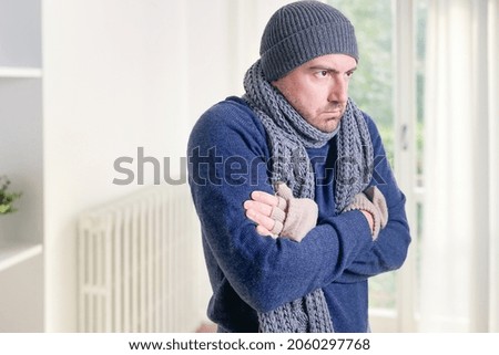 Man feeling cold at home with home heating trouble Royalty-Free Stock Photo #2060297768