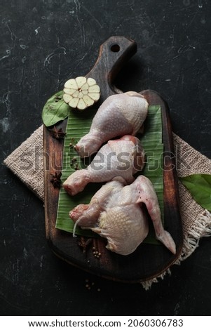 pieces of fresh chicken meat that are ready to be processed into dishes, served on a cutting board,on dark background