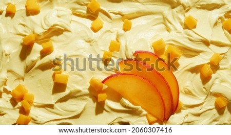 Top view of delicious cold ice cream decorated with slices of fresh peach in daylight