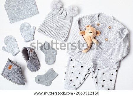 Collection of cute organic  baby clothes and booties. Warm gender neutral outfit for cold weather of fall and winter season. Newborn gifts, baby shower, second hand clothes, donation idea.
