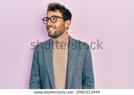 Handsome man with beard wearing business jacket and glasses looking to side, relax profile pose with natural face and confident smile.  Royalty-Free Stock Photo #2060313449