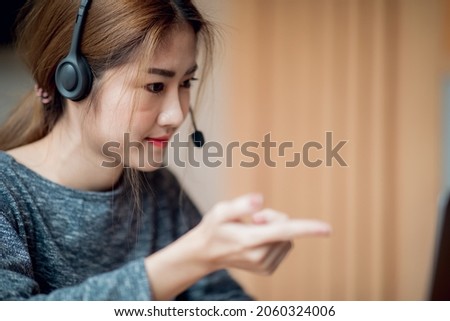 Young attractive university student using a laptop computer, studying online at home. Cheerful caucasian asian woman writes notes, planning working process, sitting at home. Exam preparation. 