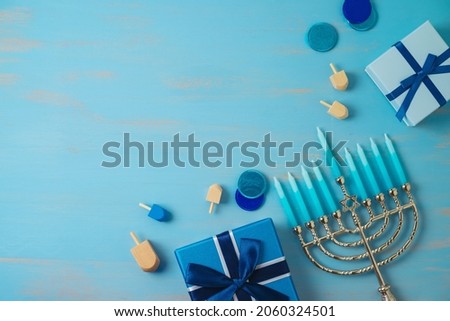 Jewish holiday Hanukkah background with menorah and gift box on wooden table