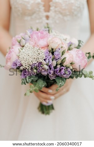 beautiful bridal bouquet holding a white wedding dress