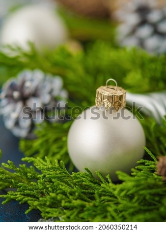 Beautiful Christmas and New Year's composition of coniferous branches, a white Christmas ball and cones. Christmas, New Year, winter holidays. Greeting card, interior decor.