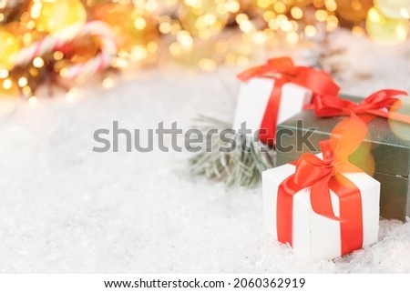 Beautiful Christmas gifts with pine branch, snow and bokeh lights on the background with copy space. Post card, discount voucher or sale concept. 