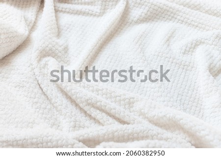 Beige delicate soft background of plush fabric. wrinkle fleece blanket. fuzzy soft texture. side view