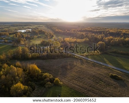 countryside roads in autumn colors with sunset light. drone image above ground aerial