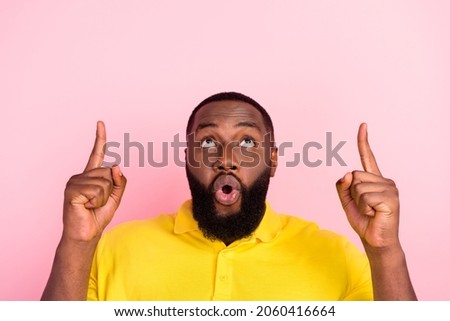 Photo of afro american amazed shocked young man look point finger up empty space solution isolated on pink color background