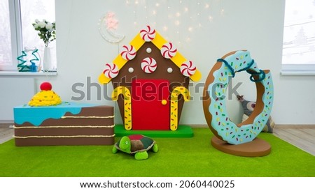 Children's photo zone in the form of a chocolate house and sweets. Bright play area for children. Birthday decor. Childhood happiness