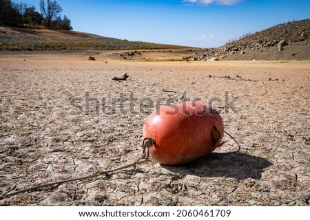 An orange buoy lying on an empty marina area of Folsom Lake California. Water levels are at historic lows due to lack of rain, hot weather and water releases. Royalty-Free Stock Photo #2060461709