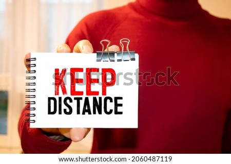Text - keep distance. Top view written on white paper on a desktop. Medical concept