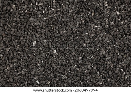 Seamless texture and full-frame background of coconut activated charcoal used as chemical adsorbent material. Close-up of black dry granular carbon . Royalty-Free Stock Photo #2060497994