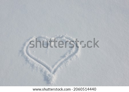 Heart painted on white fluffy snow. Valentine's Day, Christmas, New Year concept. Card with copy space.