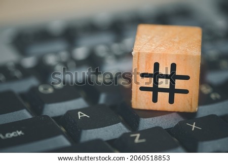 Hashtag symbol on wooden cube put on black computer keyboard. Close up