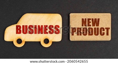 Business concept. On a black background, a car - business and a sign with the inscription - NEW PRODUCT