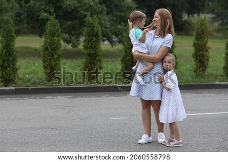 Portrait of smiling young mother hugging her children son and daughter. A happy family.