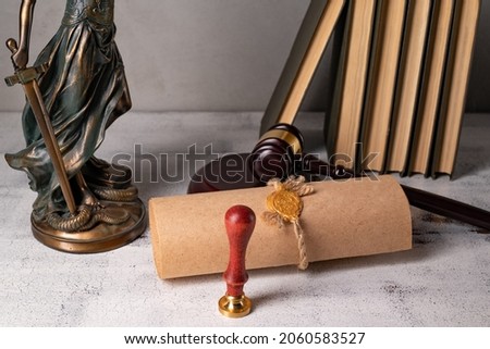 Lady Justice, Judge's gavel, books, parchment scroll with seal and stamp on an old wooden table