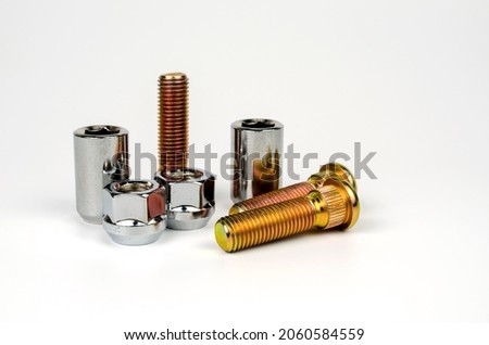 metal stud and shiny car wheel nuts close-up on a white background. car spare part