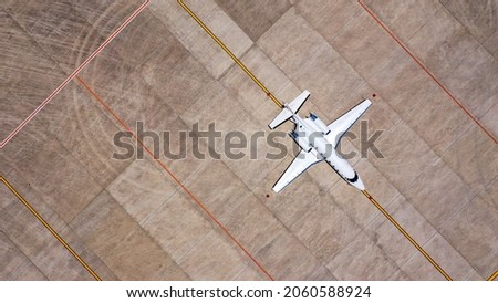 Parked expensive private airplane on concrete ground of airport, aerial. Small business jet parked on the runaway Royalty-Free Stock Photo #2060588924