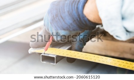 man measures metal with a ruler for cutting, hands close-up