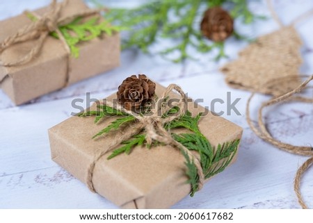 Christmas composition. Christmas gifts,  pine cones,  branches on a wooden white background. Top view, copy space. Christmas and New Year holidays background
