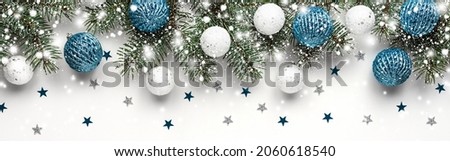 Christmas white background with fir branches, white and blue balls. New year card. Copy space, flat lay, top view. Banner