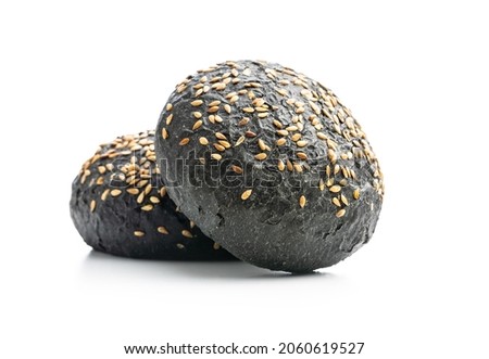 Black bun. Dark pastry with sesame seeds isolated on white background.