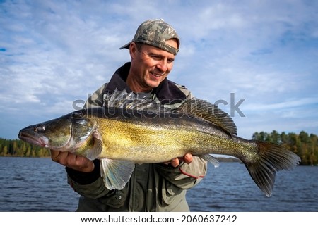 Angler holding a huge zander fish Royalty-Free Stock Photo #2060637242