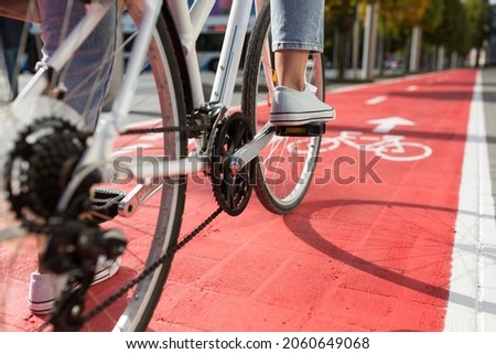 traffic, city transport and people concept - close up of woman cycling along red bike lane with signs of bicycles and two way arrows on street Royalty-Free Stock Photo #2060649068