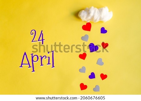 24 april day of month, colorful hearts rain from white cotton cloud on yellow background. Valentine's day, love and wedding concept