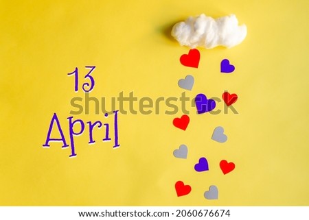 13 april day of month, colorful hearts rain from white cotton cloud on yellow background. Valentine's day, love and wedding concept