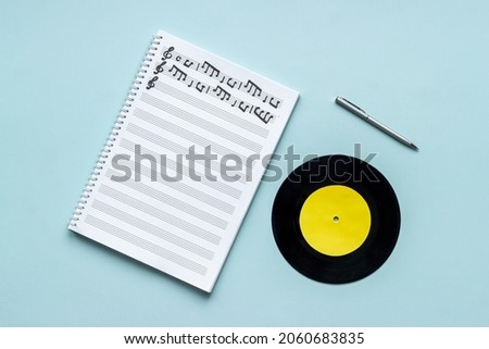 Handwritten music sheets and vinyl record, top view. Compose music concept