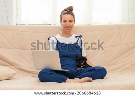 Woman working at home with a little dog