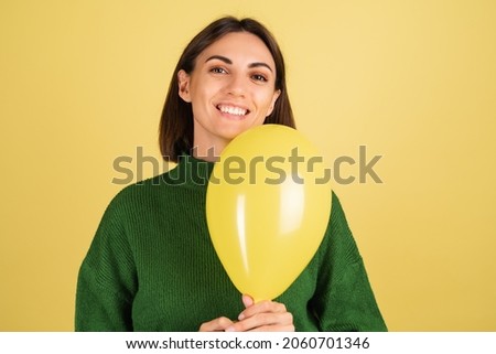 Young woman in green warm sweater happy cute smiling with air balloon, holiday mood, celebration