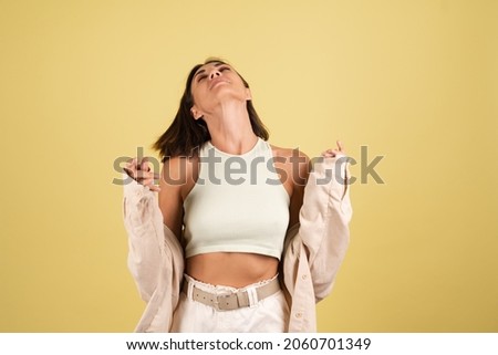 Indoor studio portrait of woman on yellow background happy positive moving cheerful