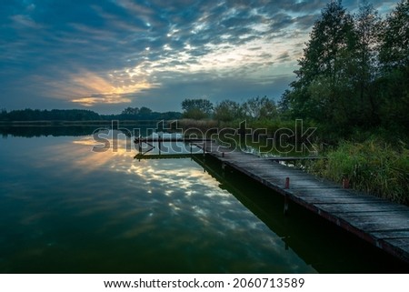 Pier over the lake and the sunset behind the clouds, Stankow, Lubelskie, Poland