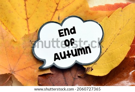 End of autumn text on a cloud on autumn leaves