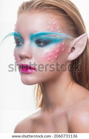 Portrait of a adorable blonde in the image of an elf posing at the studio. On a white background