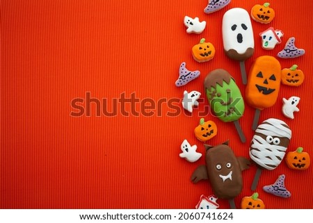 Set of ice cream and cookies with halloween character face on orange background. Halloween party background