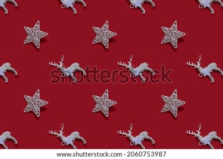 Christmas pattern of white star and toy deer on traditional red background