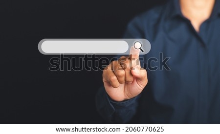 Search engine online concept. Hand of a man pressing search button for searching information on the web browser on virtual screen while standing with a black background.