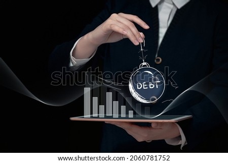 debt crisis concept, weight with the inscription debt in hand over a bar graph, default and bankruptcy background, huge corporate and external debt, Royalty-Free Stock Photo #2060781752