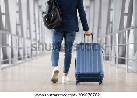 Unrecognizable Man With Bag And Suitcase Walking In Airport Terminal, Rear View Of Young Male On His Way To Flight Boarding Gate, Ready For Business Travel Or Vacation Journey, Cropped, Copy Space Royalty-Free Stock Photo #2060787821