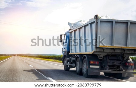 Transporting waste in a dump truck on the highway for recycling. Transportation of recyclable materials to a processing plant. Copy space for text Royalty-Free Stock Photo #2060799779