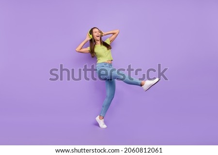 Full length body size view of pretty overjoyed carefree cheerful girl listening rock dancing isolated over purple violet color background