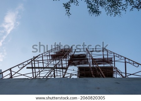 tall scaffolding for the work of a building, photo from the bottom facing up with a blue sky