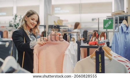 Beautiful Smiling Female Customer Shopping in Clothing Store, Choosing Stylish Clothes, Picking Dress, Blouse. People in Fashionable Shop, Colorful Brand, Sustainable Designs, New Seasonal Collection Royalty-Free Stock Photo #2060828555