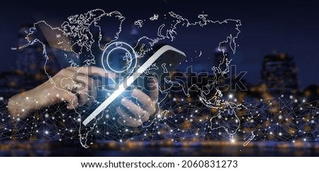 Concept on business, politics, ecology and media. Hand touch white tablet with digital hologram world, earth, map, Location Marker sign on city dark blurred background