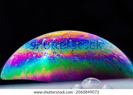 soap bubble. Close-up. Black background. Bright colors. Side view. A high resolution. Imitation of an unknown planet. Children's entertainment. Science fiction.